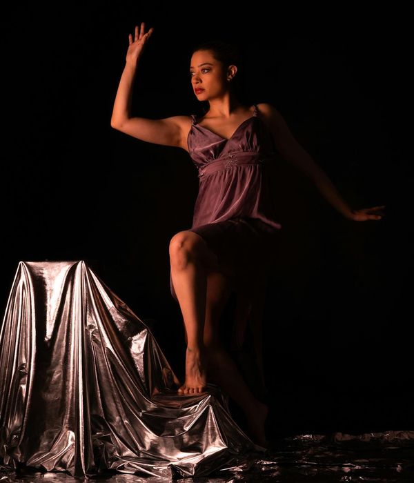 Active woman performing rhythmic exercises in a modern dark studio