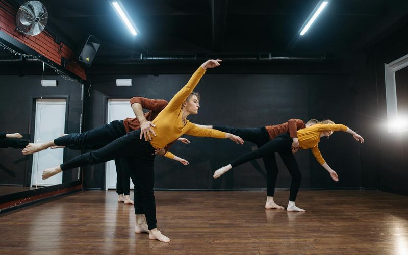 Group of people practicing synchronized cardio movements in studio
